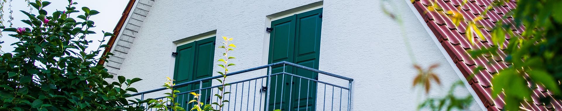 blick auf einen balkon mit geschlossenen jalousien